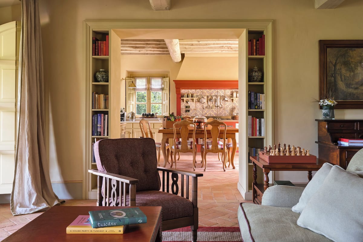 Una sala de estar acogedora con chimenea, un comedor y una cocina visibles a través de un arco abierto.