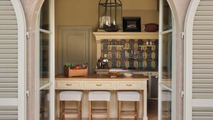 Un arco abierto que da a una cocina con techo de madera, un farol colgante y salpicadero de azulejos.