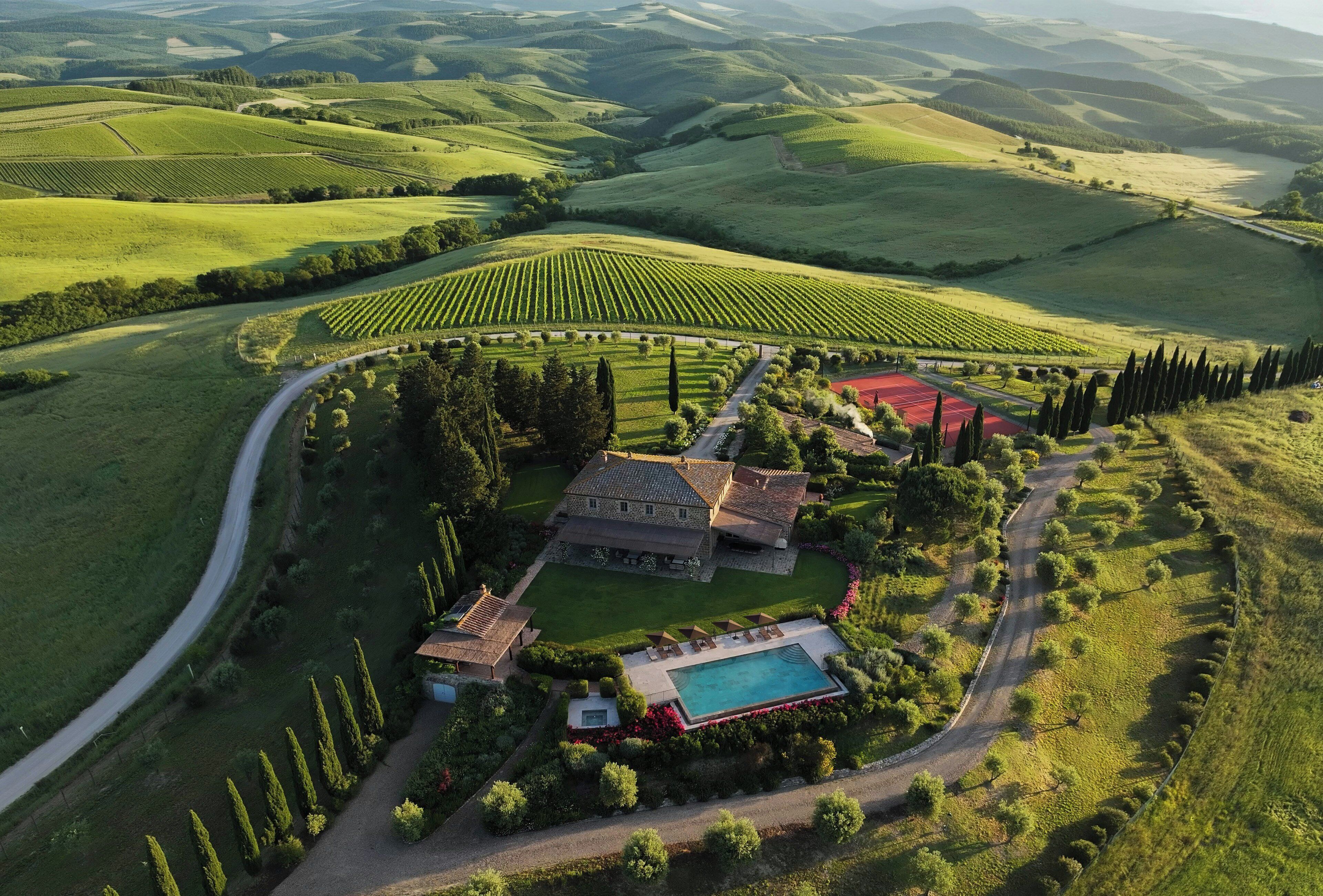 A large estate with a swimming pool, a tennis court, and a vineyard.