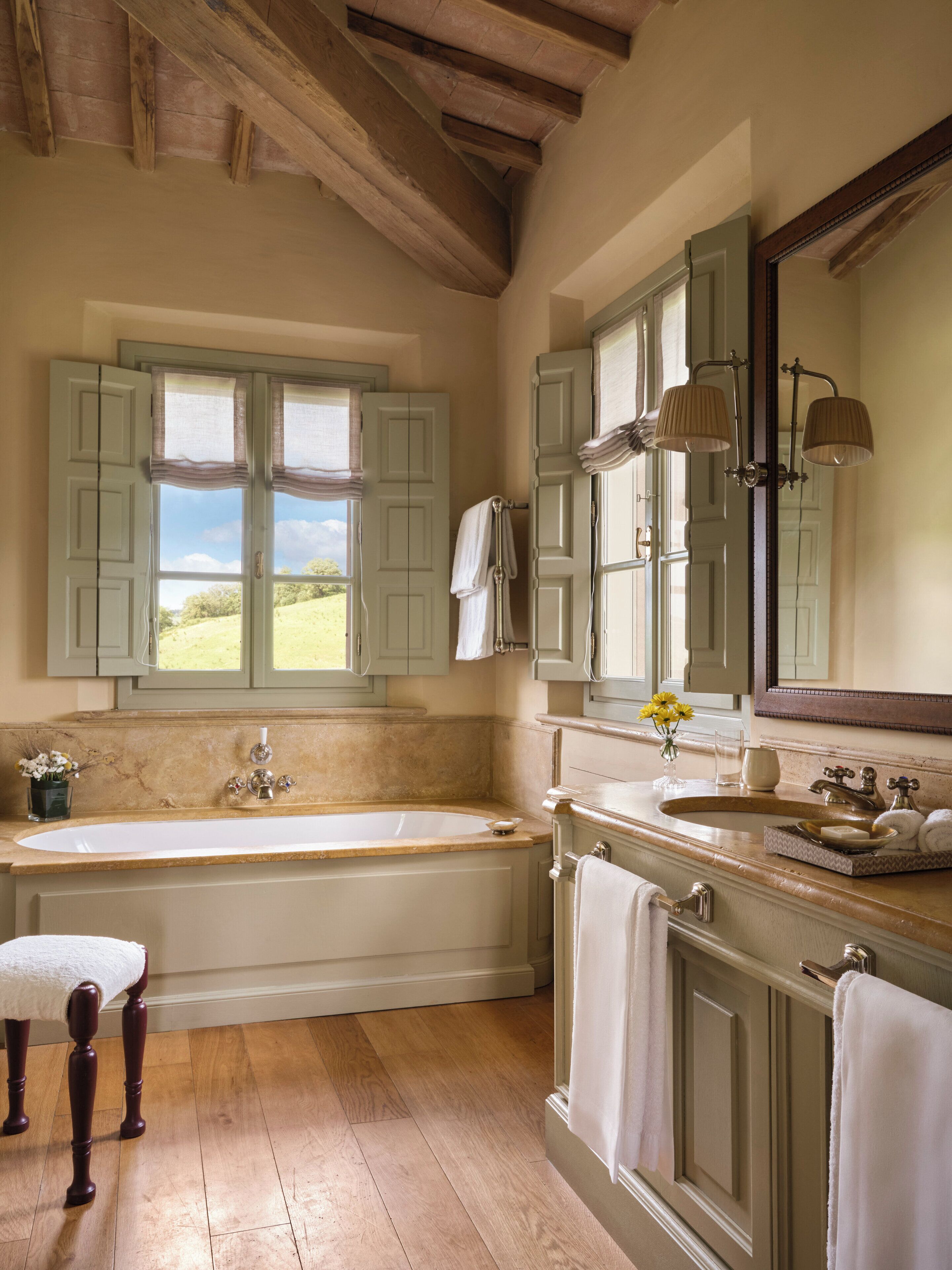 A bathroom with a bathtub, vanity, and large mirror.