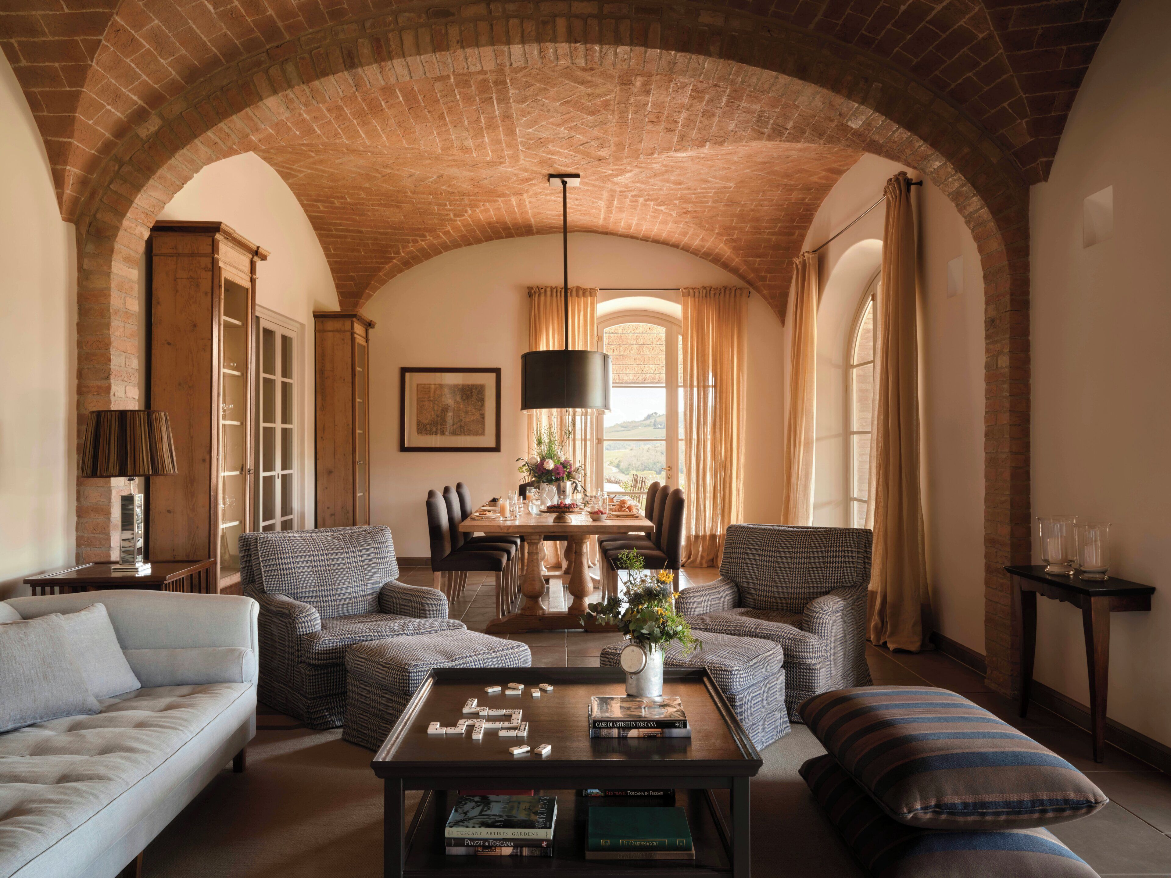 A dining area with a brick ceiling, a table set for four, and a view of the outdoors.