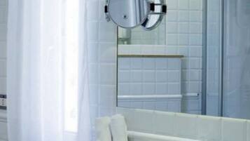 Un baño con lavamanos blanco, espejo y cortina de ducha.