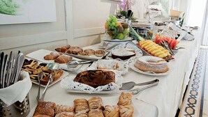 A buffet table with various pastries, fruits, and a cake. - Hotel Sirolo (Sirolo)