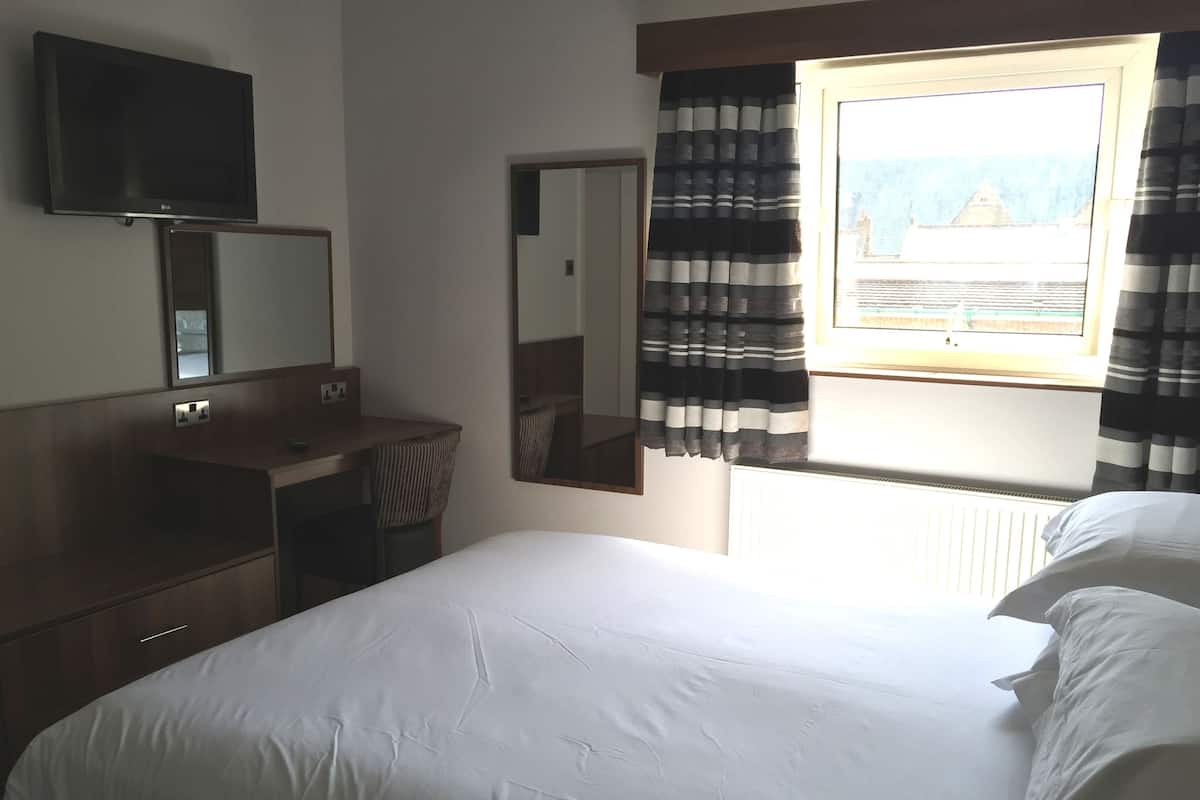 Tabla de planchar con plancha, acceso a internet y ropa de cama
