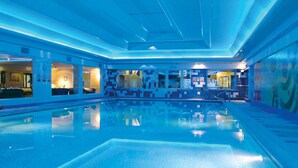 A large indoor swimming pool with a tiled floor and walls, surrounded by a blue-lit interior. - Dalmeny Resort Hotel (Lytham St. Anne's)