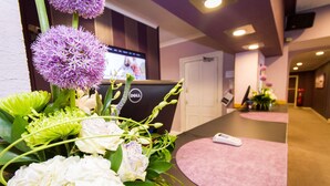 A reception area with a desk, a computer, and a remote control on a pink mat. - Dalmeny Resort Hotel (Lytham St. Anne's)