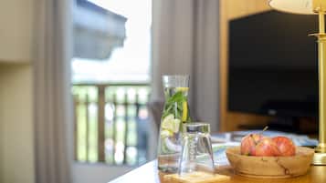 Ein Holztisch mit einem Wasserglas, einem Zitronenlimonaden-Glas, einem Salzstreuer und einer Schüssel Äpfel.