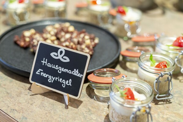 A dessert display with various sweet treats and a sign that reads "Hausgemachter Energieriegel".