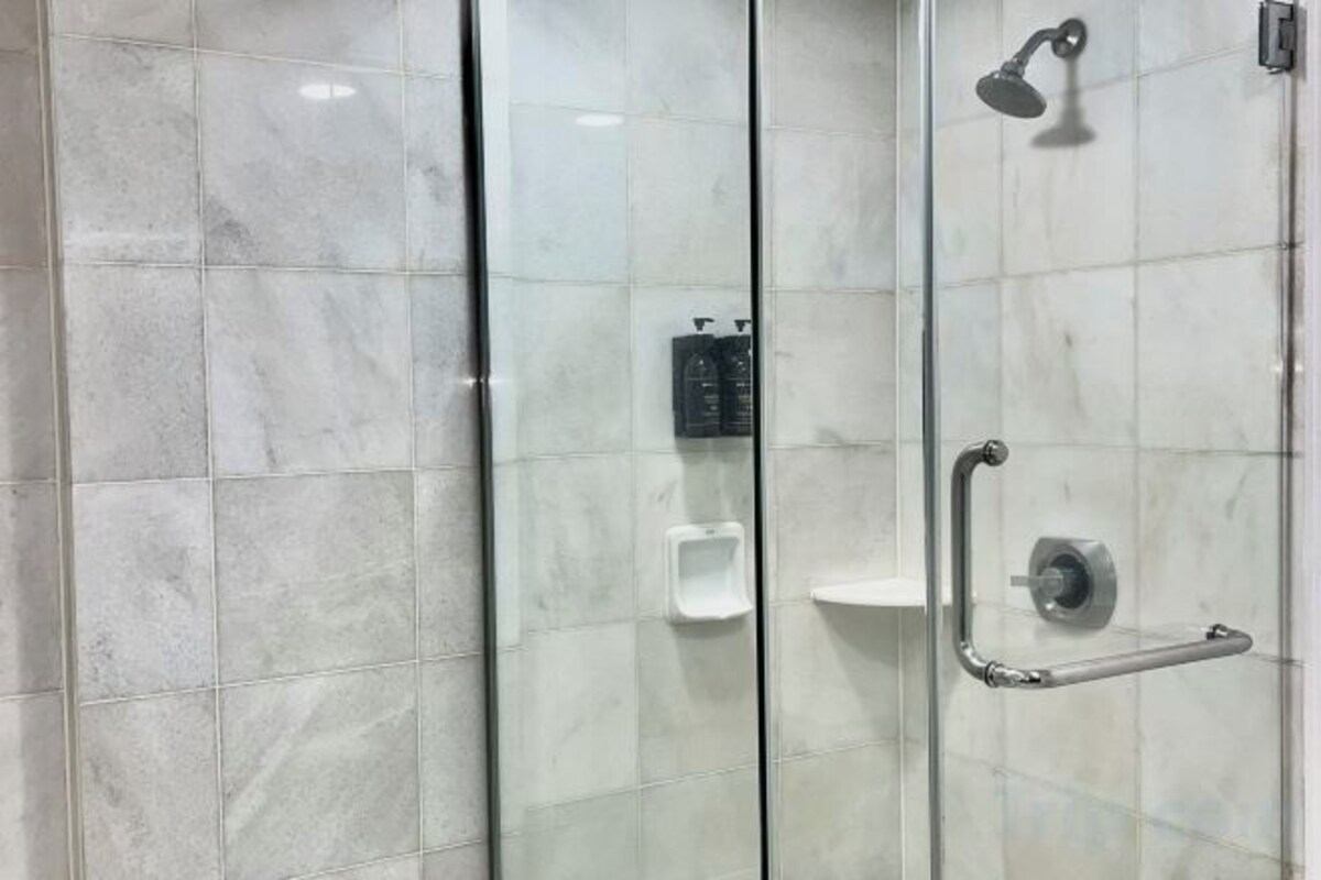 Een aparte badkuip en douche, gratis toiletartikelen, een haardroger