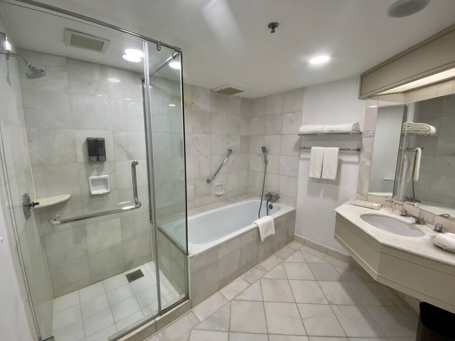 Un bagno moderno con doccia vetrata, una vasca freestanding e un mobile lavabo con specchio.