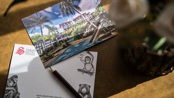 A business card and a brochure for Sabah Hotel Sandakan, featuring a resort with a pool and palm trees.