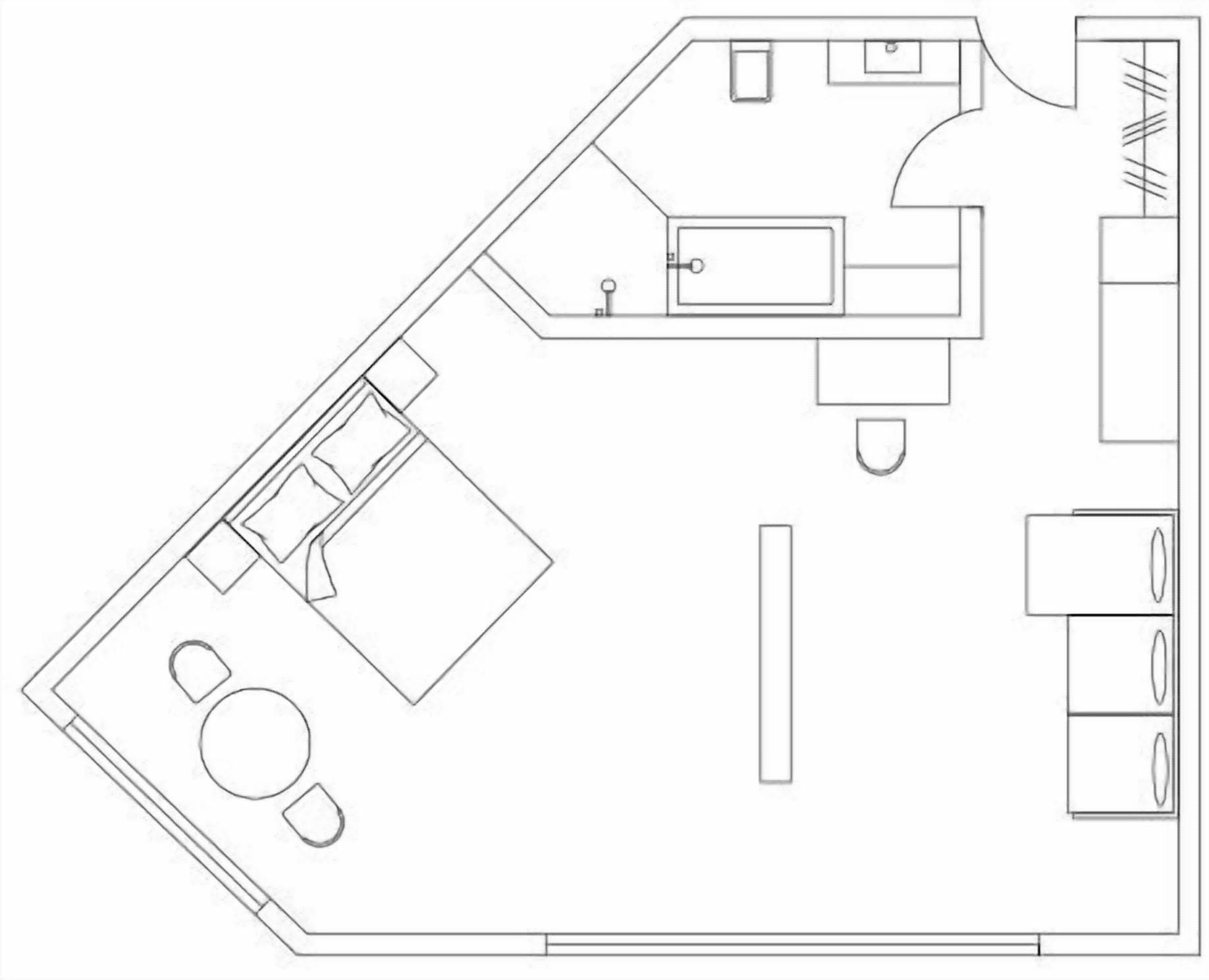 A floor plan of a hotel room with a bed, a bathroom, a kitchenette, and a seating area.
