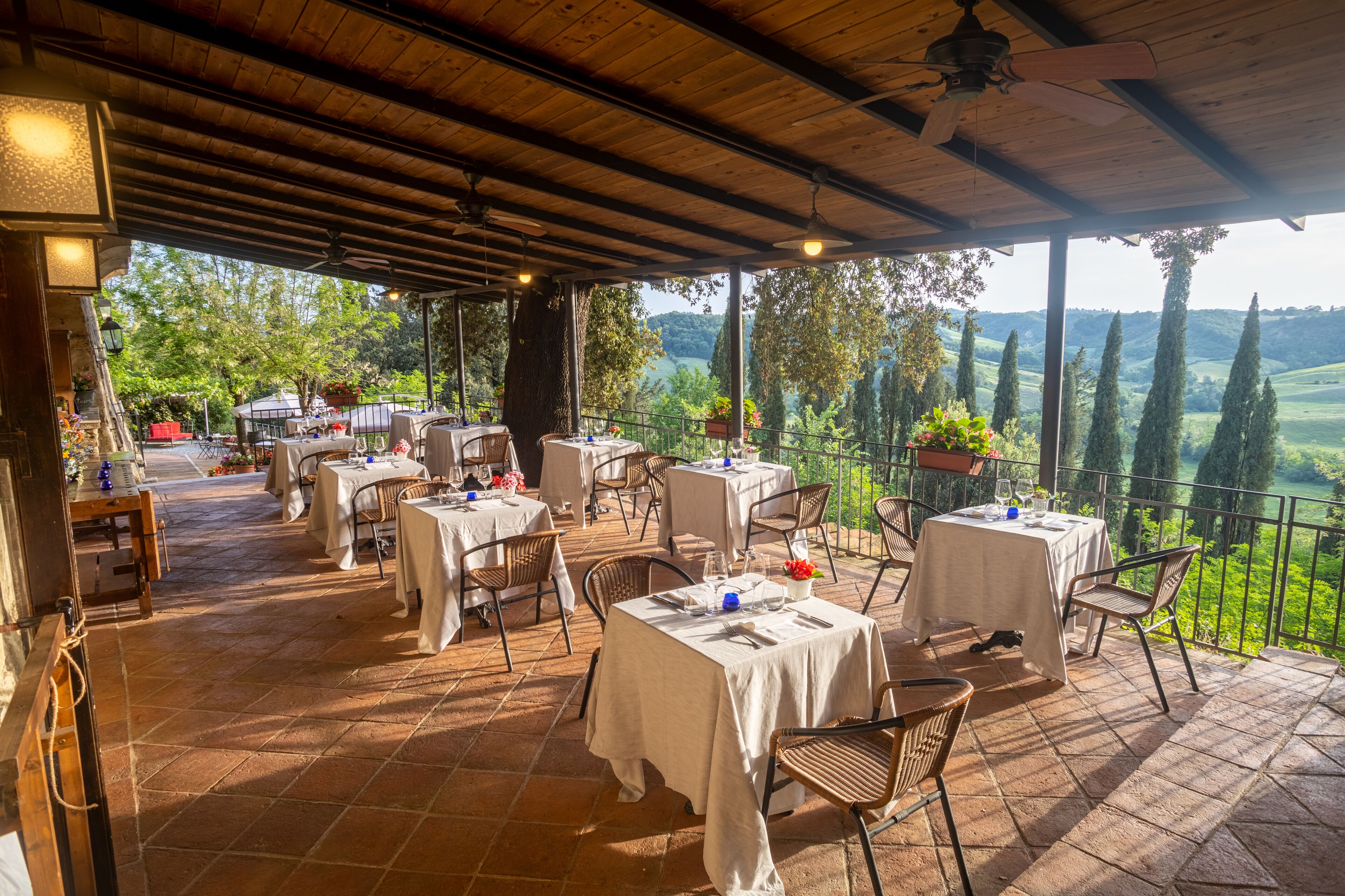 An outdoor patio with tables and chairs, overlooking a scenic landscape.