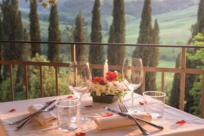A table set for two with wine glasses, a candle, and a flower arrangement. - Laticastelli Country Relais (Rapolano Terme)