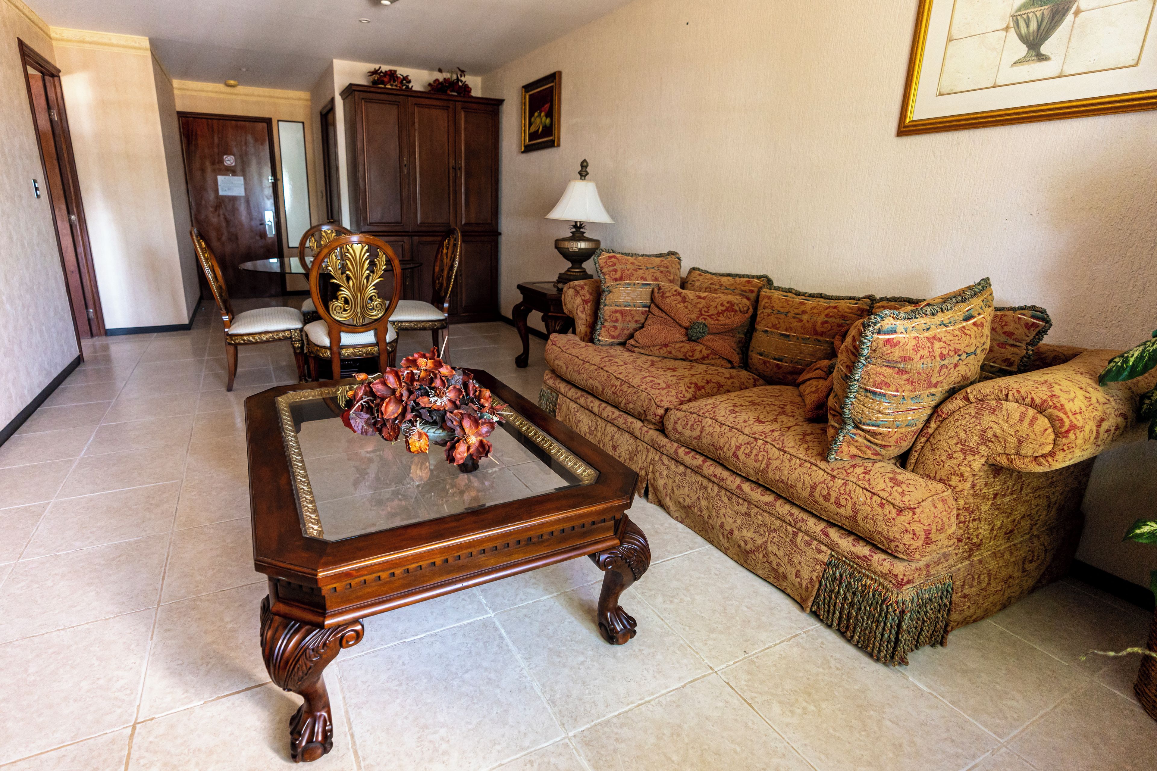 A living room with a wooden coffee table, patterned sofa, and a decorative vase.