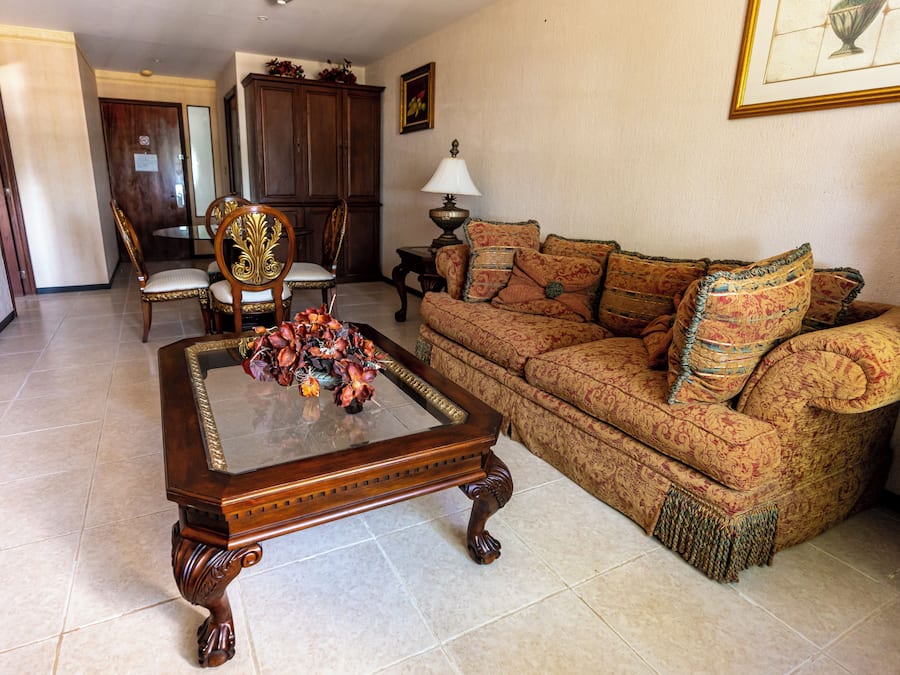 A living room with a wooden coffee table, patterned sofa, and a decorative vase.