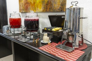 A beverage station with two large dispensers, a milk pitcher, and a coffee machine.