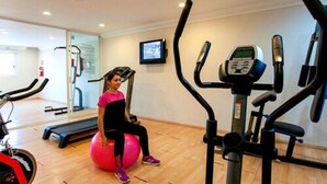 A gym with exercise equipment, a treadmill, and a seated exercise ball. - Ocean View Hotel (Campeche)