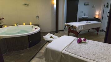 Relax in a serene spa room with a hot tub and massage table.