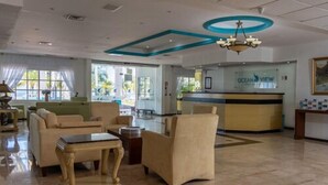 A hotel lobby with a reception desk, seating area, and a chandelier. - Ocean View Hotel (Campeche)