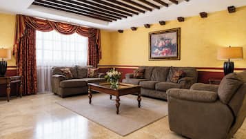 A living room with two sofas, a coffee table, and a painting on the wall.