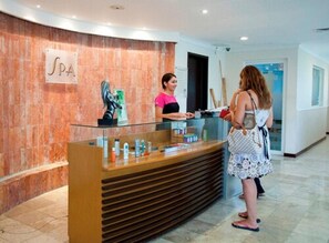 A reception desk with a marble wall, a sign reading "SPA", and a statue. - Ocean View Hotel (Campeche)
