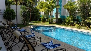 A swimming pool with lounge chairs and a garden area. - Ocean View Hotel (Campeche)