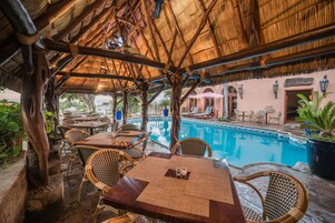 Una piscina al aire libre, sombrillas, sillones reclinables de piscina