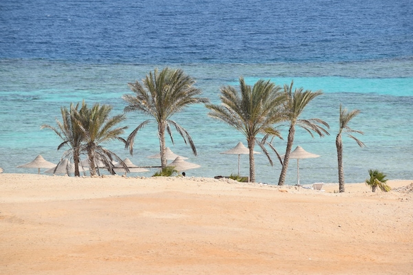 Aan een privéstrand, ligstoelen, parasols, strandlakens