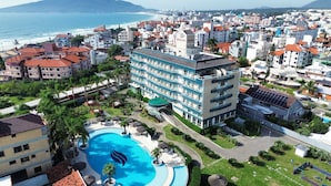 A hotel with a swimming pool, multiple floors, and a view of the sea. - Oceania Park Hotel Spa & Convention Center by RB Hotelaria (Florianópolis)