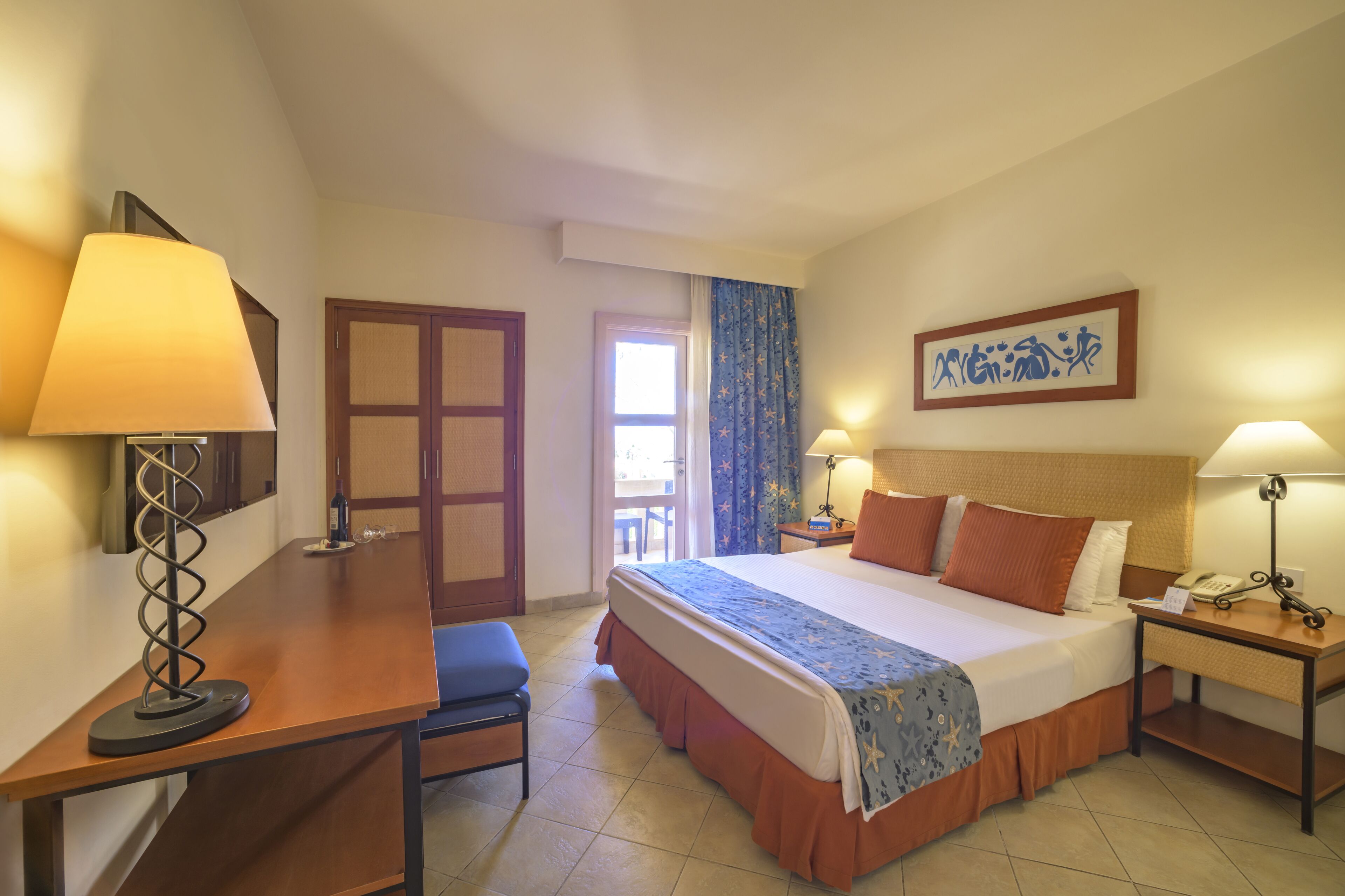 Una habitación de hotel con una cama, mesitas de noche, un escritorio y una silla.