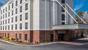 A Comfort Inn hotel with a brick facade, multiple windows, and a clear sky. - Comfort Inn & Suites Lumberton Central I-95 (Lumberton)