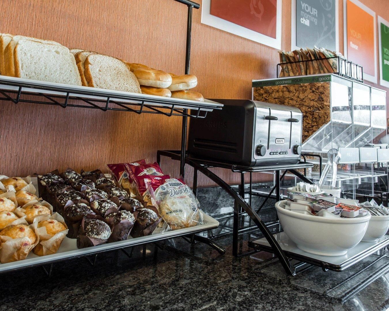 Een ontbijtbuffet met brood, gebak en een broodrooster.