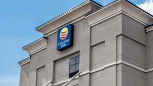 Un bâtiment arborant l’enseigne « Comfort Inn », avec un logo stylisé représentant le soleil et la lune.