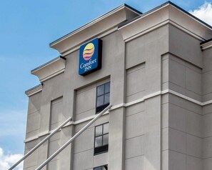 A building with a Comfort Inn sign, featuring a stylized sun and moon logo. - Comfort Inn & Suites Lumberton Central I-95 (Lumberton)