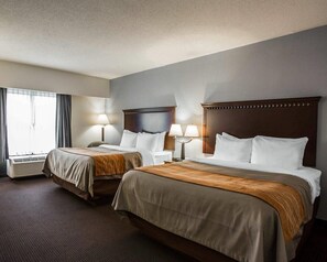 A hotel room with two beds, each with a wooden headboard, bedside lamps, and a window with curtains. - Comfort Inn & Suites Lumberton Central I-95 (Lumberton)