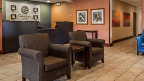 A hotel lobby with wicker chairs, a reception desk, and framed artwork on the walls. - Comfort Inn & Suites Lumberton Central I-95 (Lumberton)