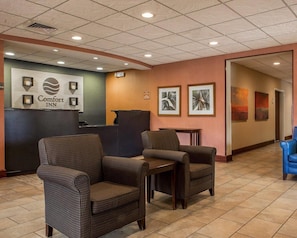 A hotel lobby with wicker chairs, a reception desk, and framed artwork on the walls. - Comfort Inn & Suites Lumberton Central I-95 (Lumberton)