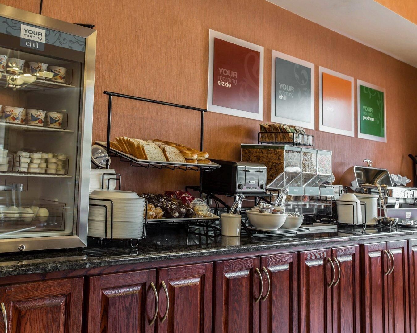 A breakfast bar with various food items, a coffee machine, and a toaster.