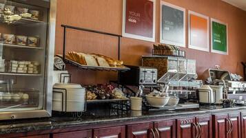 A breakfast bar with various food items, a coffee machine, and a toaster.