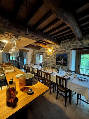 Enjoy a meal in this charming dining area with a long table set for a meal, surrounded by rustic charm.