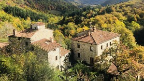 A stone building with a tiled roof surrounded by autumn foliage. - Bio Agriturismo il Vigno (Caprese Michelangelo)
