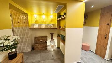 A bathroom with yellow walls, a wooden cabinet, a sink, and a mirror.