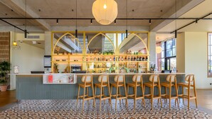A bar area with a counter, bar stools, and a variety of bottles and glasses. - Kyriad Prestige Compiègne Hotel & Spa (Compiègne)