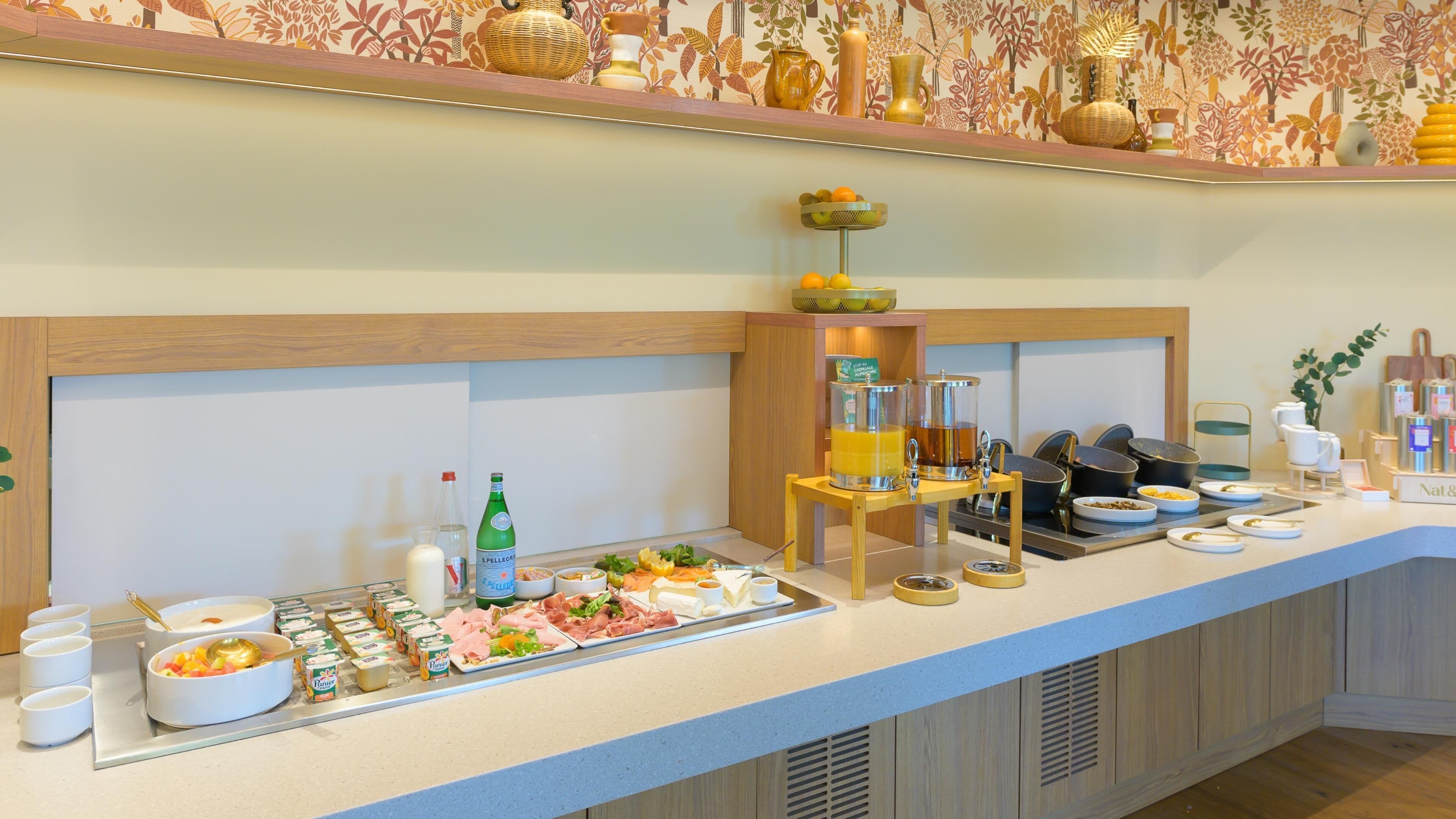 A buffet setup with various food items, beverages, and condiments.