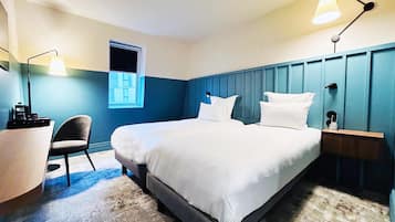 A bedroom with a bed, a chair, a desk, and a window.