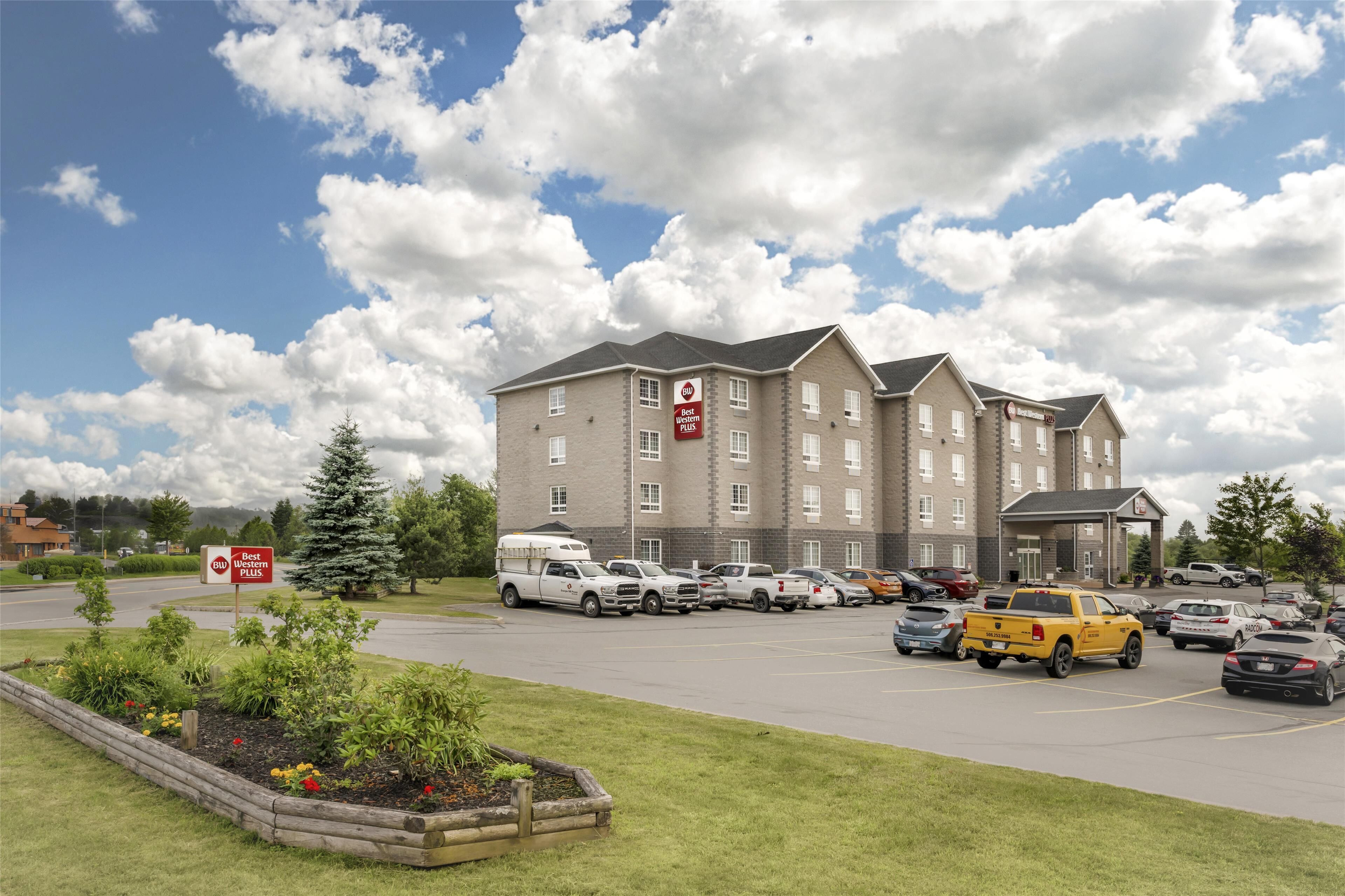 A multi-story hotel with a parking lot in front.