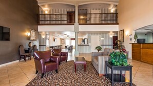 A spacious lobby with a high ceiling, a dining area, and a reception desk. - Best Western Plus Main Street Inn (Brawley)