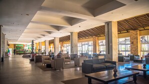Un hall d’entrée spacieux doté de plusieurs espaces de détente, d’un bar à café et de grandes fenêtres laissant entrer la lumière naturelle.