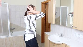Un baño con bañera, lavamanos y puerta de madera.